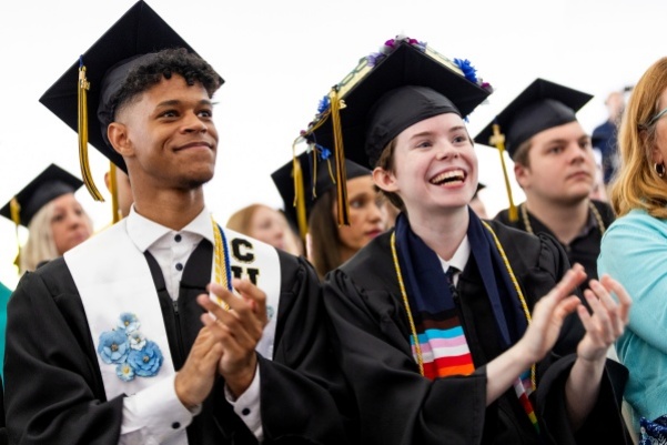 Graduates clapping at Commencement.